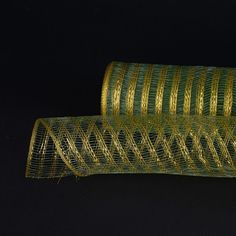 two rolls of green and gold wire on a black background