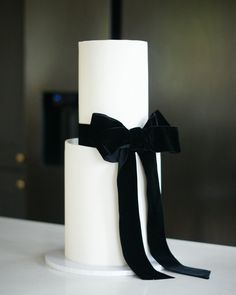 a white cake with black ribbon on top