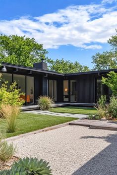 a modern house with grass and trees in the background