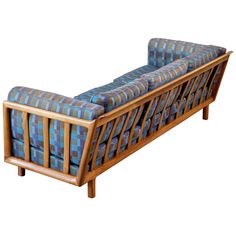 a blue and green checkered couch sitting on top of a wooden frame