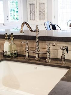 a kitchen sink with two faucets and soap dispensers on the counter