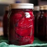 jars filled with red liquid sitting on top of a table