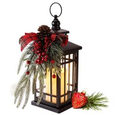 a lantern with christmas decorations on it and a red ornament next to it