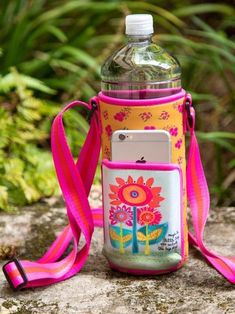 a water bottle with a cell phone in it sitting on top of a stone wall