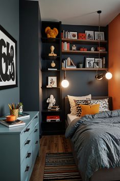 a bedroom with blue walls and wooden flooring is decorated in black, orange, and white