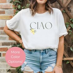 This Ciao Lemon Shirt, a charming blend of language and nature that's perfect for any wardrobe. This Italian Lemon Tee combines the timeless greeting "Ciao" with a beautiful lemon design, capturing the essence of Italy's sunny citrus groves. Our Lemon Shirt is more than just a piece of clothing; it's a celebration of Italian culture and the natural beauty of lemons. All of our shirts are made with the highest quality materials and are super soft and cozy! ♥ HOW TO ORDER ♥ 1. See photos for sizing and color options 🌈 2. Choose your quantity. Feel free to add as many shirts as you wish! ✨ 3. Select your size(s) and color(s) from the drop-down menus.  4. Click "ADD TO CART" to add the shirt to your virtual cart.  🛒 5. Click "PROCEED TO CHECKOUT" to purchase your shirt. 6. Your shirt is now Spring Brunch Cotton T-shirt, Spring Cotton T-shirt For Brunch, Crew Neck Cotton Shirt For Brunch, Cotton Crew Neck Shirt For Brunch, Casual Crew Neck Shirt For Brunch, Lemon Shirt, Lemon Design, Italian Culture, Language Teacher