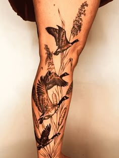 a man's leg with birds and flowers on it