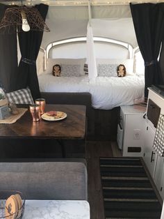 the interior of a camper with two beds and a table in front of it