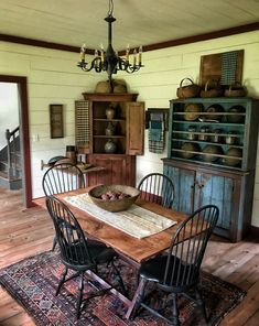 a dining room table and chairs in front of a hutch