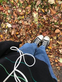 a person with their feet up on the ground in front of some leaves and grass