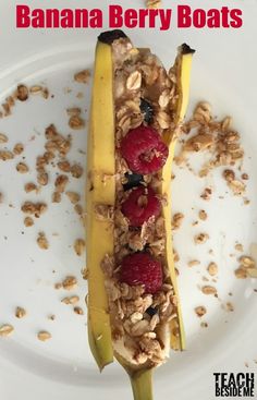 banana berry boats on a white plate with granola and raspberries in it