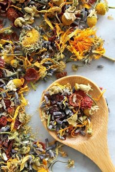 a wooden spoon filled with dried flowers on top of a table