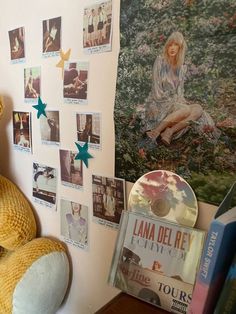 a teddy bear sitting in front of a wall with pictures on it and a cd