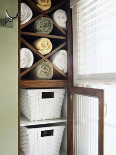 towels are stacked on top of baskets in the closet