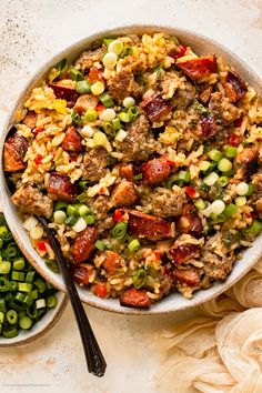 a bowl filled with rice, meat and veggies next to some green beans