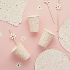 pink and white table setting with polka dot napkins, paper straws, cupcake sticks, and flowers