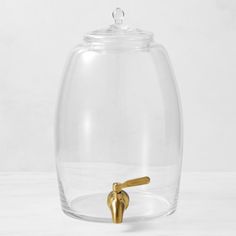 a glass jar with a gold handle on it