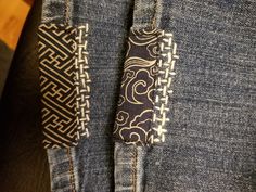 a pair of blue jeans with black and white designs on them