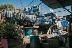 an outdoor area with clothes hanging on the line, and a man working in front of it