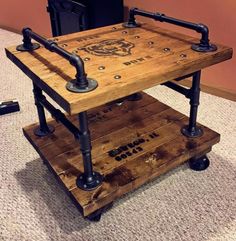 a wooden table with metal pipes on it and a black trash can in the background