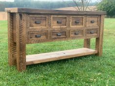 a wooden bench with drawers on it in the grass