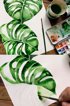 someone is painting a large green leaf on paper with watercolors and paintbrushes