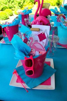 pink and blue table setting with flamingos on the napkins, cups and glasses