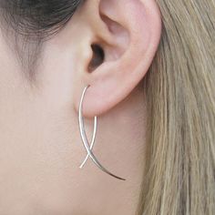 One of our favourite earring styles for wearing to the office, these minimalist and on trend Overlap Sterling Silver Drop Earrings feature a delicate geometric silver wire design that's sure to get you noticed! Lightweight, affordable, and just large enough to be noticed, the earrings thread through a piercing and come with a silver butterfly fastening that's hidden behind the ear. An elegant earring perfect for gifting. Also available in 18kt Gold and Rose Gold plated finishes. Made from: Sterling silver and 18kt gold and rose gold plating. Measurements: Drop length approx. 4.0cm. Silver Threader Earrings, Earrings Minimal, Gold Diamond Earrings Studs, Wire Design, Ear Climber, Minimal Earrings, Unusual Earrings, Sterling Silver Drop Earrings, Heart Shaped Diamond