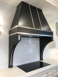 a black stove top oven sitting inside of a kitchen next to white counter tops and cabinets