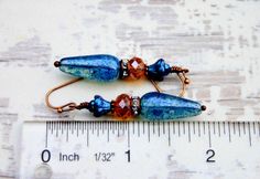 Rustic Copper dangles with beautiful blue & amber Czech glass beads & sparkly crystal copper rings...Uniquely Beautiful! Uniquely hand crafted with these quality materials: ~ Czech glass fire polished faceted beads ~ Crystal encrusted copper spacer rings ~ Antiqued copper findings & lead & nickel-free French style ear wires ~ Silicone earring backs to keep earrings securely in ears Measuring 2 inches from the top of the ear wires to the bottom of the beads, they're light weight & Adjustable Blue Bohemian Teardrop Earrings, Vintage Blue Hypoallergenic Earrings, Blue Hypoallergenic Vintage Earrings, Handmade Blue Bohemian Crystal Earrings, Blue Bohemian Crystal Drop Earrings, Bohemian Blue Crystal Drop Earrings, Vintage Blue Beaded Drop Earrings, Bohemian Blue Beaded Hypoallergenic Earrings, Bohemian Blue Hypoallergenic Beaded Earrings