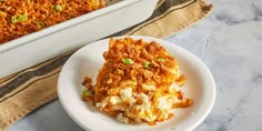 a white plate topped with food next to a casserole dish