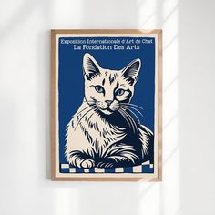 a blue and white poster with a cat on it's side hanging from the wall