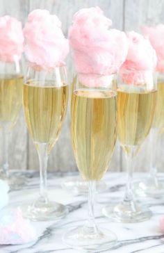 four champagne flutes filled with pink frosting on top of a table