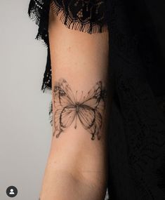 a woman's arm with a butterfly tattoo on the left side of her arm