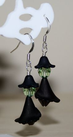 two black witches hats are hanging from earrings