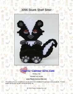 a crocheted skunkk stuffed animal sitting on top of a white background