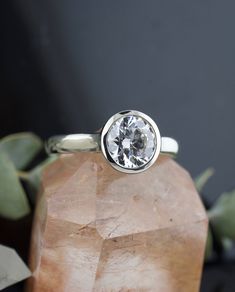 a diamond ring sitting on top of a rock