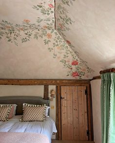 a bed sitting under a painted ceiling in a bedroom