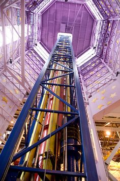 the inside of a large building with many pipes and ladders on each side of it