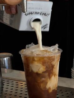 a person pours milk into a cold drink