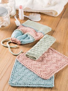 three crocheted washcloths on the floor with toothbrushes and other items