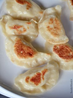 some dumplings are sitting on a white plate