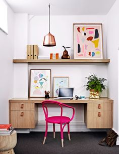 a pink chair sitting in front of a desk