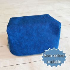 a blue cushion sitting on top of a wooden floor next to a sign that says more options available