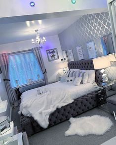 a bedroom with a bed, chair and chandelier in the middle of it