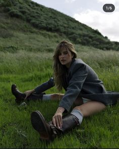 a woman sitting in the grass with her legs crossed