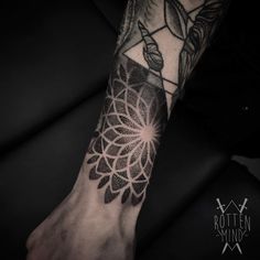 a person's arm with a tattoo on it and a flower in the middle