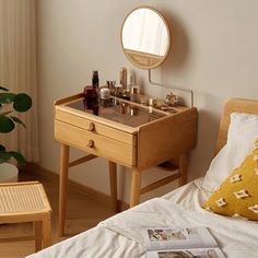 a bedroom with a bed, table and mirror on the wall next to a potted plant