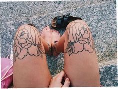 two women's legs with tattoos on them