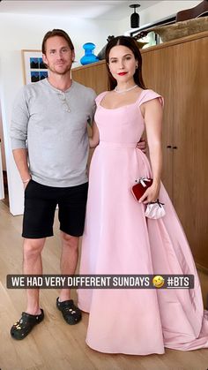 a man standing next to a woman in a pink dress